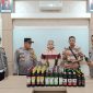 WS (63 thn) beserta puluhan botol miras, berhasil diamankan di Mapolsek  Prigen (foto: ist)