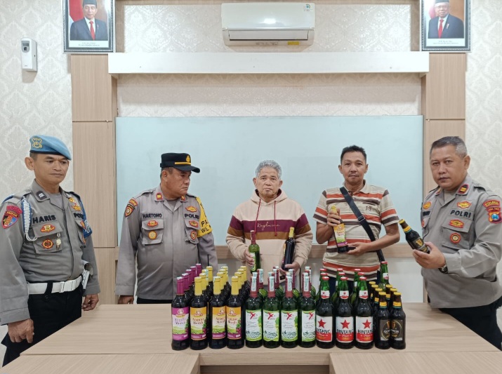 WS (63 thn) beserta puluhan botol miras, berhasil diamankan di Mapolsek  Prigen (foto: ist)