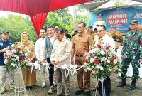 Pemotongan Pita oleh Pj. Bupati Pasuruan, Dr. Nurkholis, sebagai simbolis seremonial di bukanya acara pasar murah di Desa Karangjati Pandaan (Dok. Harianjatim.id)