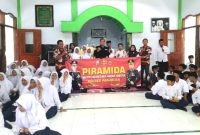 Kasi Humas Polres Pasuruan, Iptu. Joko Suseno, saat berfoto bareng dewan dewan guru dan siswa-siswi MTs Nurul Qodim Wonorejo  ( Dok. Harianjatim.id)