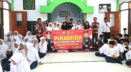 Kasi Humas Polres Pasuruan, Iptu. Joko Suseno, saat berfoto bareng dewan dewan guru dan siswa-siswi MTs Nurul Qodim Wonorejo  ( Dok. Harianjatim.id)