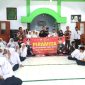 Kasi Humas Polres Pasuruan, Iptu. Joko Suseno, saat berfoto bareng dewan dewan guru dan siswa-siswi MTs Nurul Qodim Wonorejo  ( Dok. Harianjatim.id)