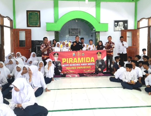 Kasi Humas Polres Pasuruan, Iptu. Joko Suseno, saat berfoto bareng dewan dewan guru dan siswa-siswi MTs Nurul Qodim Wonorejo  ( Dok. Harianjatim.id)