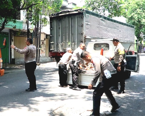 Anggota Satlantas Polres Pasuruan, saat Tambal Jalan Berlubang guna Cegah Laka Lantas  (foto: ist)