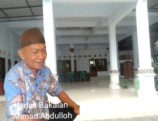 Kades Bakalan Ahmad Abdulloh saat diwawancarai awak media di Kantor Balai Desa Bakalan (Dok. Harianjatim.id)